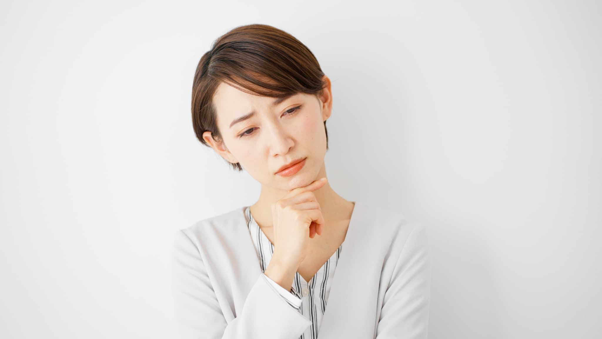 セラミック治療はなぜ高いのか考える女性